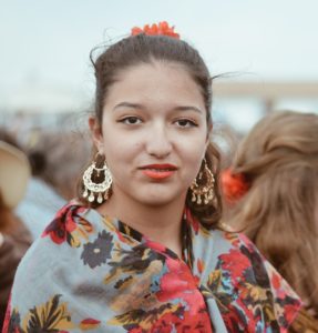 smiling woman in blue red and white floral shirt